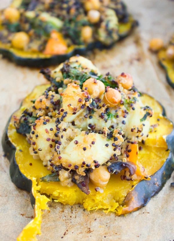 a baked acorn squash ring filled with quinoa kale stuffing
