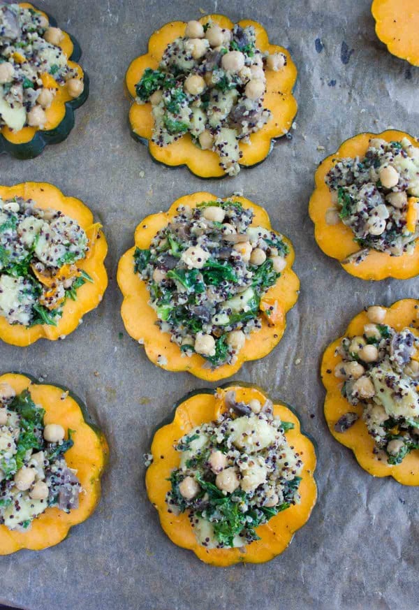 slices of acorn squash topped with Quinoa Kale Stuffing on a baking tray