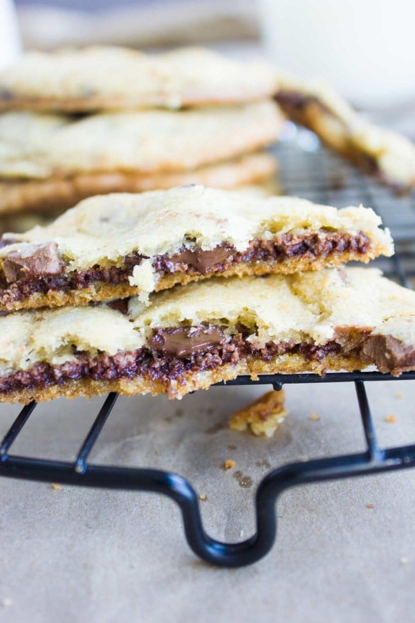 Nutella-Stuffed Chocolate Chip Cookies broken in half and stacked on top of one another