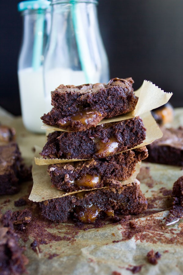 tall stack of Caramel Stuffed Spiced Brownies with golden caramel oozing out of them