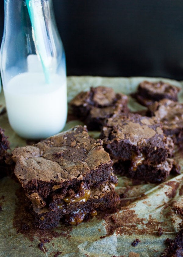 Close-up of two stacked brownies with golden caramel oozing out of the center