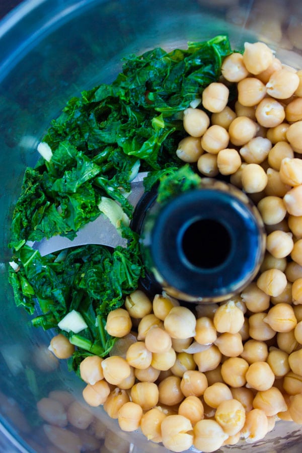 chickpeas and kale in the bowl of a food processor