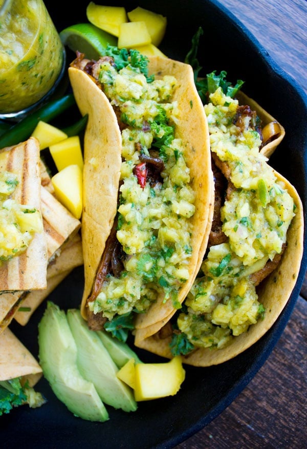 close-up of Chicken Fajita With Mango Pineapple Salsa served in hard taco shells arranged in a black skillet