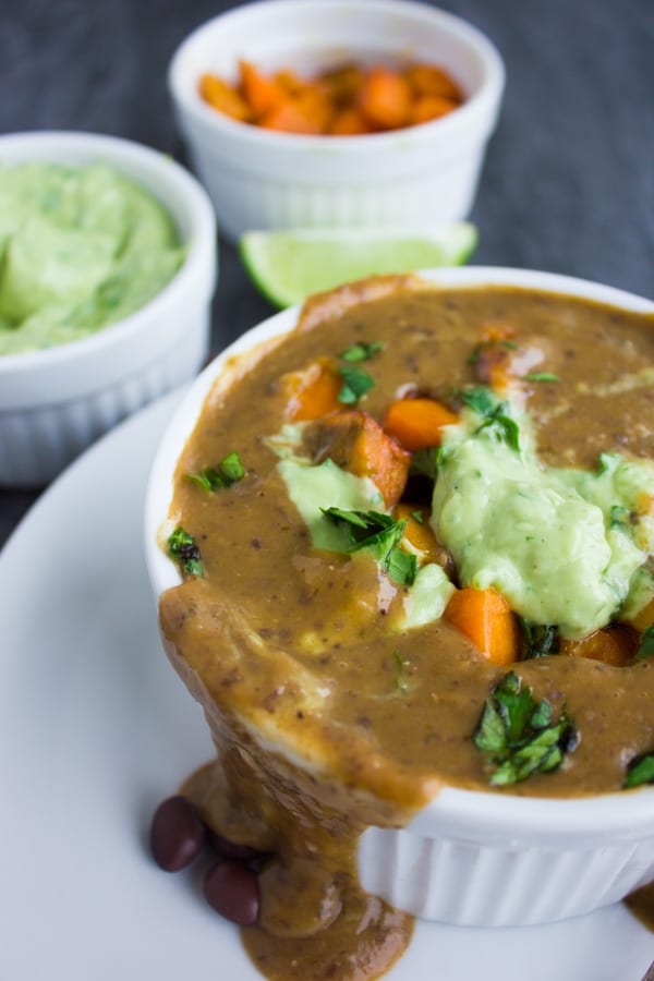 an overfilled bowl of Sweet Potato Black Bean Soup with some soup running down the side