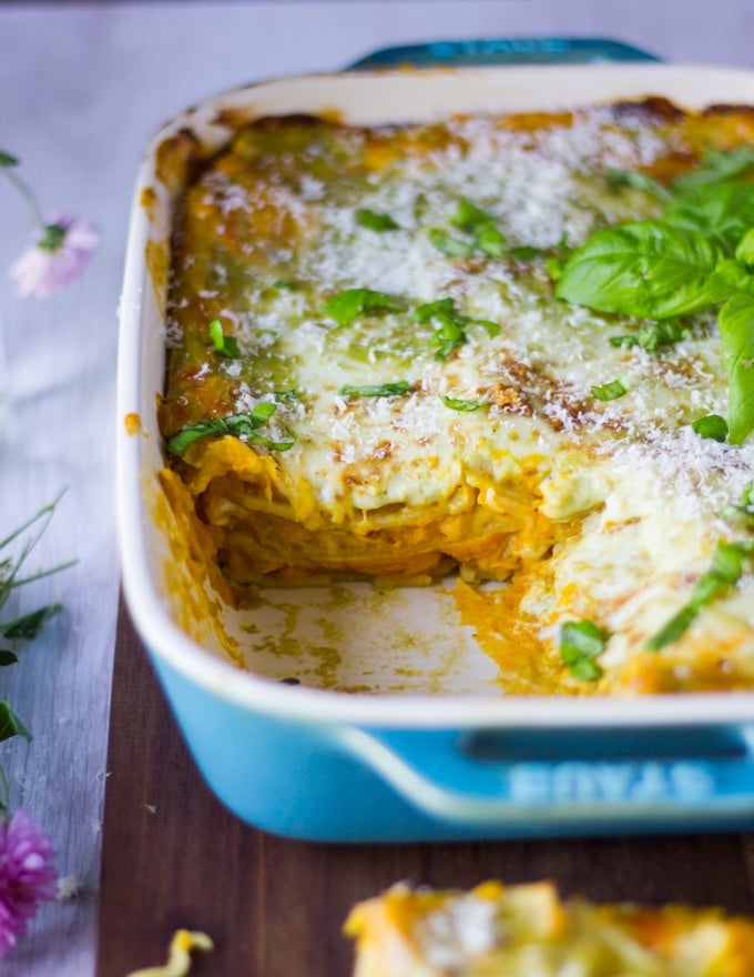 The dish of lasagna missing one piece showing close up of the layers inside the lasagna.