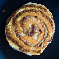 flipped cinnamon roll pancake on a skillet