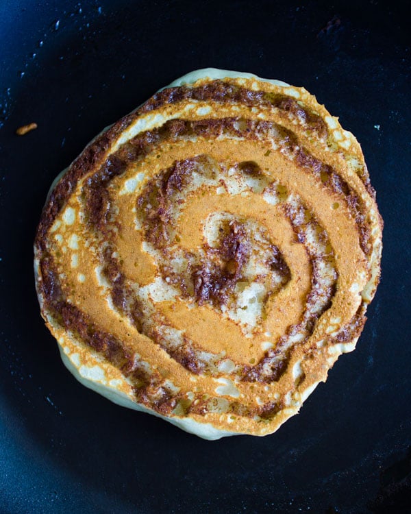 flipped cinnamon roll pancake on a skillet