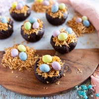 coconut brownies on a wooden board topped with toasted shredded coconut and chocolate eggs