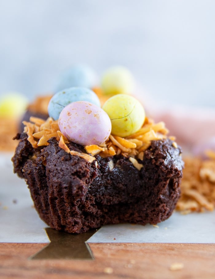 A piece of bitten coconut brownie showing the fudge brownie inside