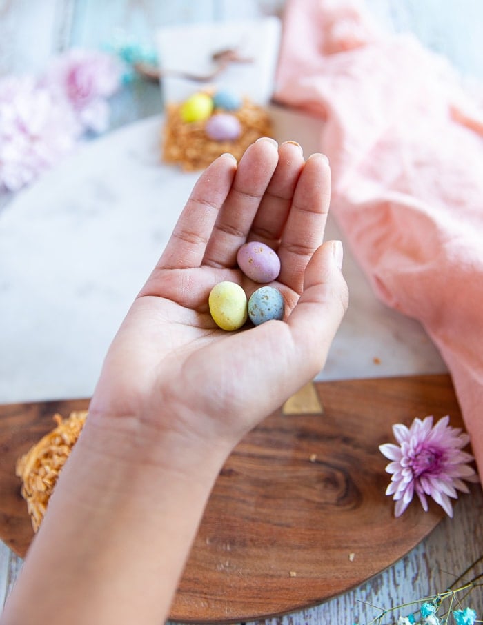 a hand holding chocolate eggs