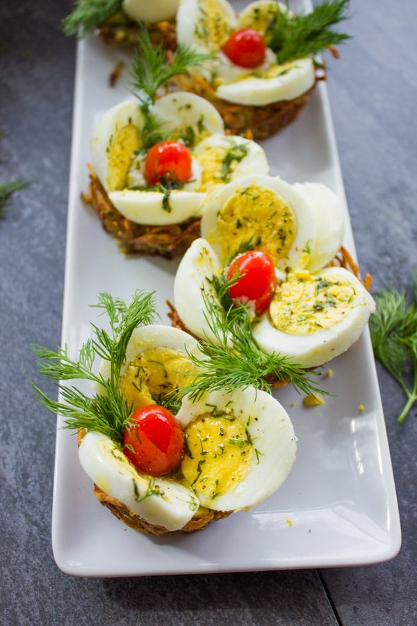 close-up of a rectangular plate with Easter Egg Tart Potato Nests topped wth fresh dill