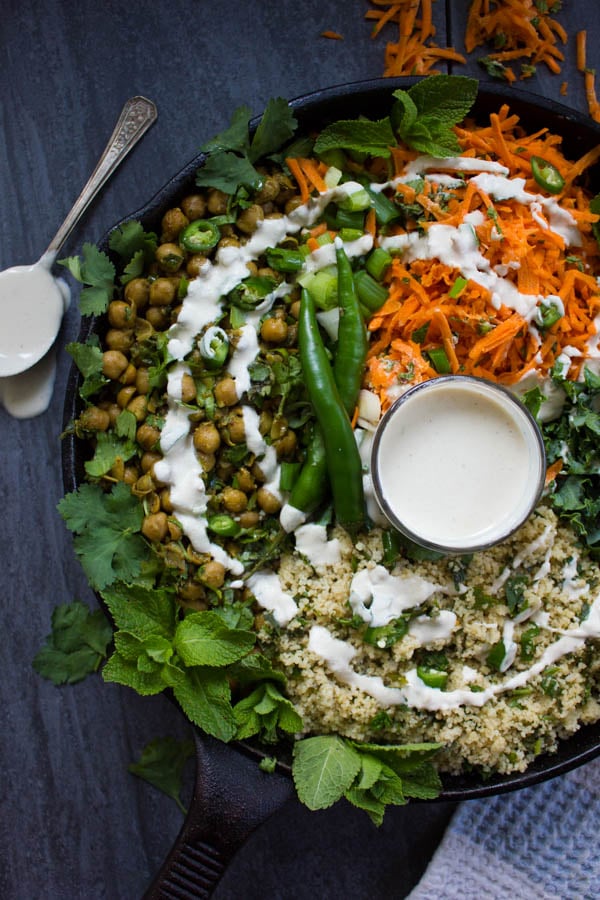 close up of the spicy chickpeas surrounded by fresh mint and drizzled with tahini sauce.