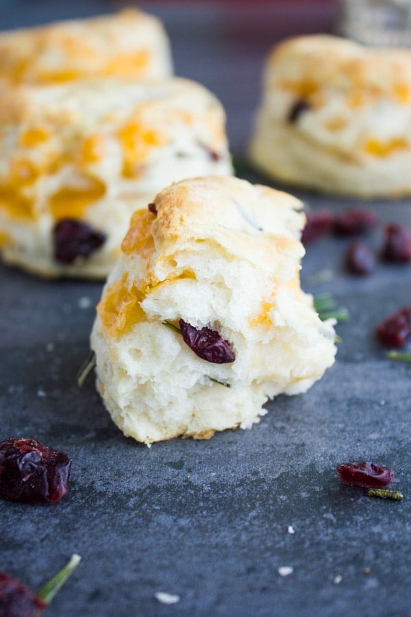 a bite of homemade biscuits surrounded with dried cranberries and rosemary