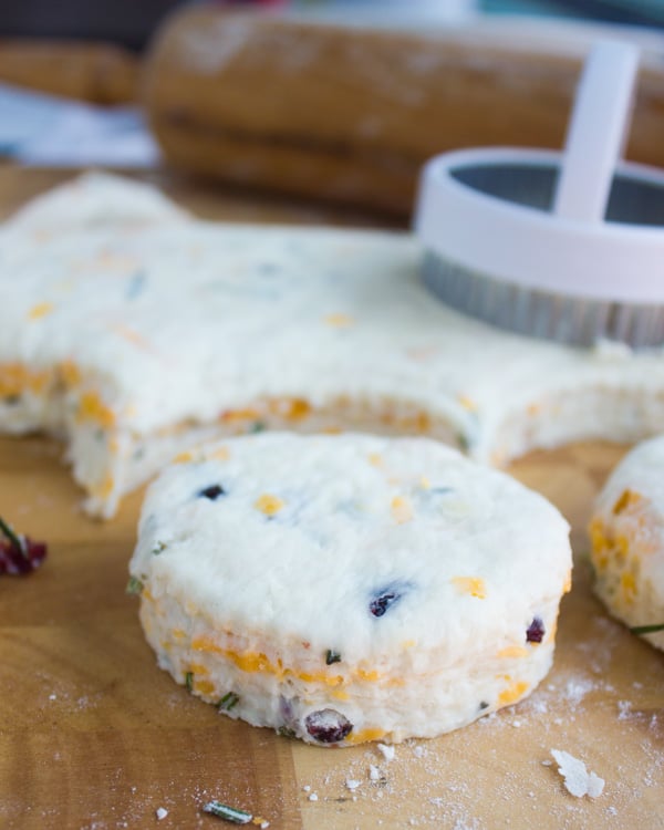 homemade buttermilk biscuits being cut out of biscuit dough with a cookie cutter