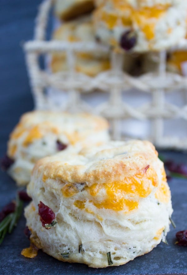 Homemade Buttermilk Biscuits With Cheddar Rosemary & Cranberries stacked on top of each other.