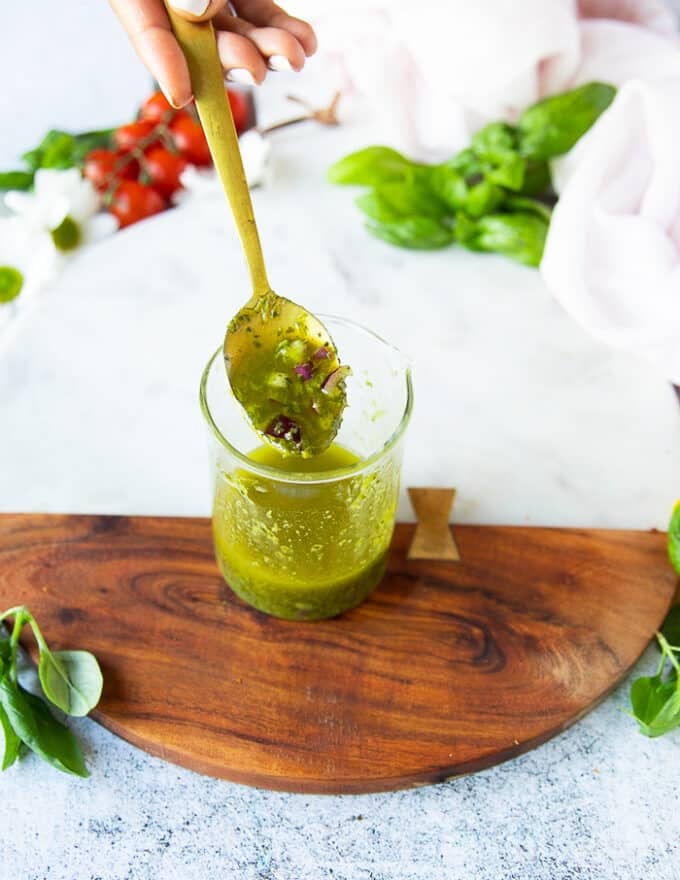 panzanella salad dressing in a bowl with a spoon showing the consistency.