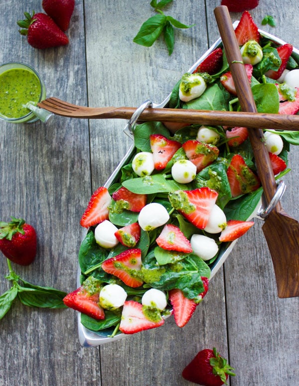 Strawberry Spinach Salad drizzled with basil vinaigrette served in a boat-shaped salad bowl