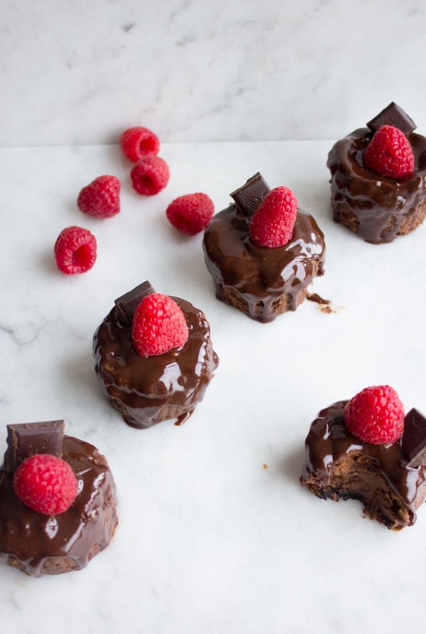 Ultimate Chocolate Cheesecakes served as mini cheesecakes topped with fresh raspberries and chocolate sauce