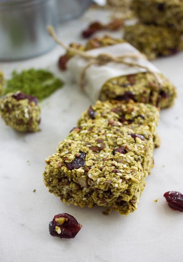 Banana Matcha granola bars with dried nuts and cranberries on a white tabletop