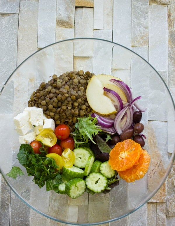 ingredients for Orange Lentil Greek Salad in a big glass bowl