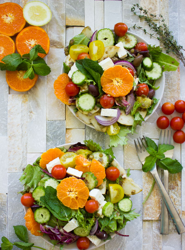 two bowls of Orange Lentil Greek Salad with feta cheese and cocktail tomatoes 
