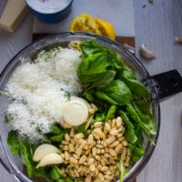 ingredients for the pistachio pesto in a bowl including pistachios, basil, parmesan, pine nuts, garlic and olive oil