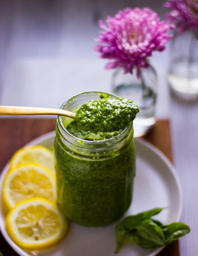 a spoonful of pistachio pesto over a jar of finished pistachio pesto 