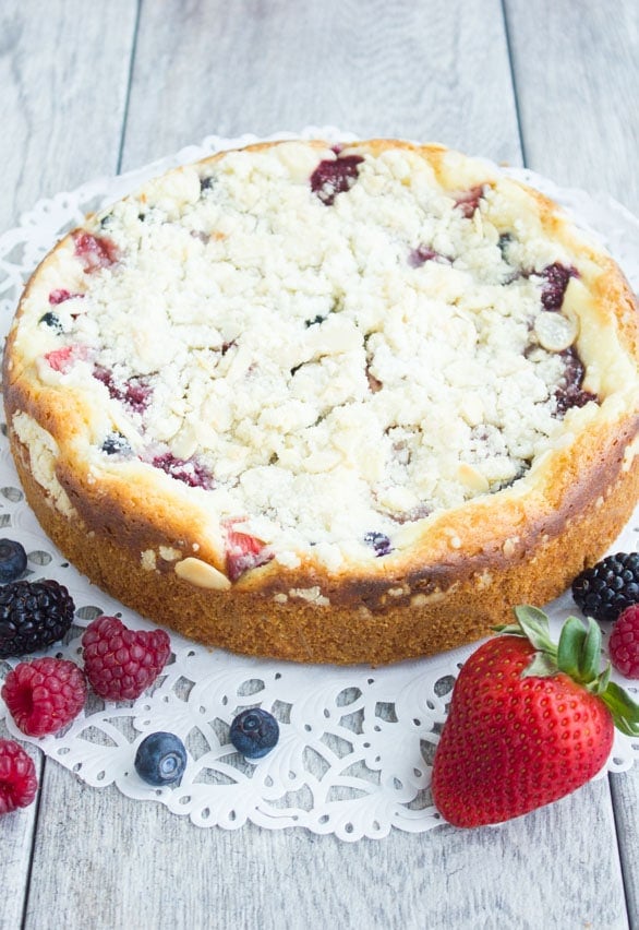 freshly baked Raspberry Cake with buttery streusel topping, dusted with powdered sugar placed on a cake doily ready to be served