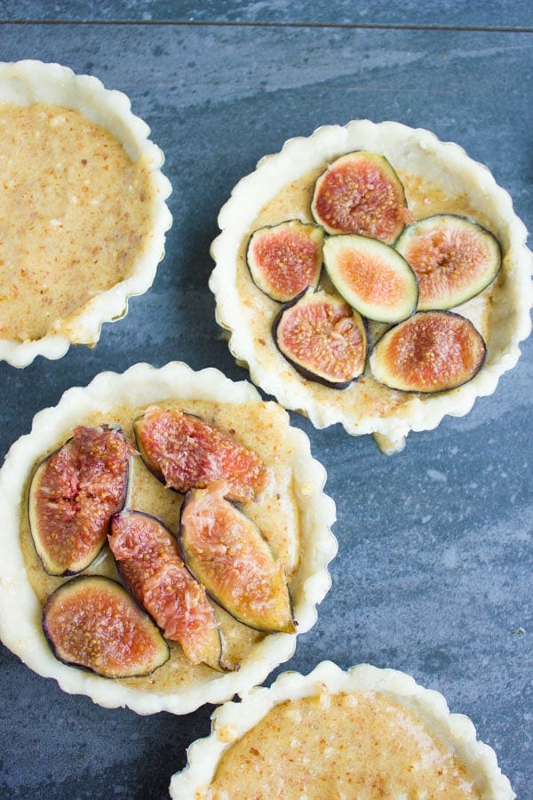 almond frangipane tarts being topped with fresh fig slices