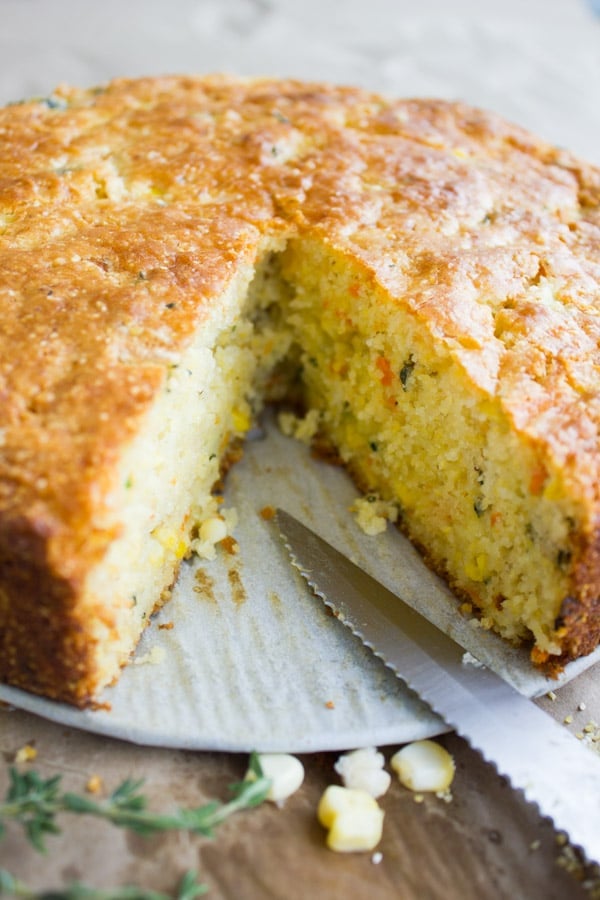 Whole cornbread out of the oven with a few slices removed showing the inside 