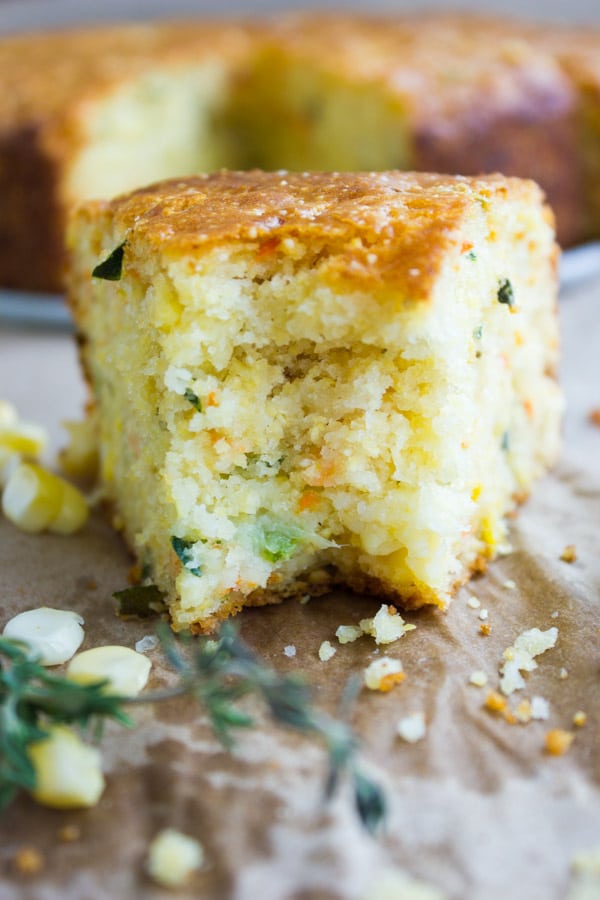 One bitten slice of cornbread showing the texture and cheese