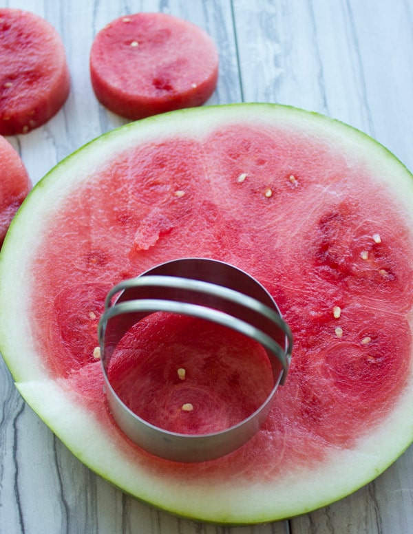 rounds being cut off a big slice of watermelon to make healthy ice cream cakes