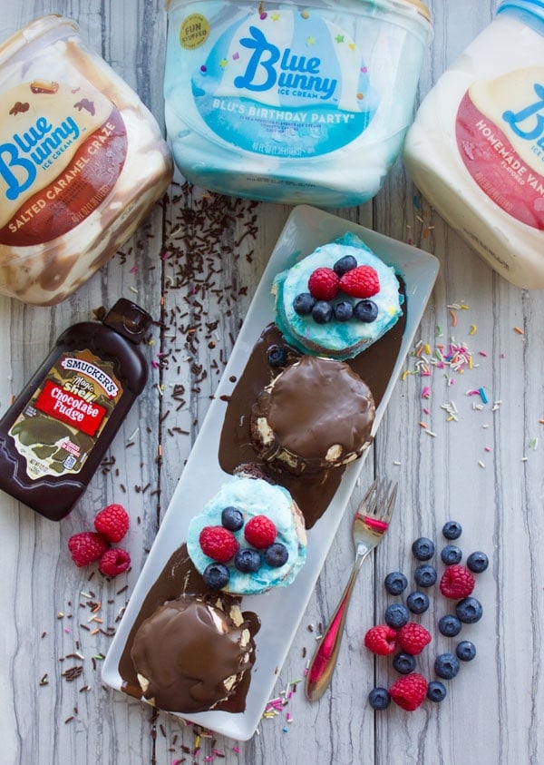 overhead shot of assorted mini ice cream cakes covered with chocolate sauce and topped with berries