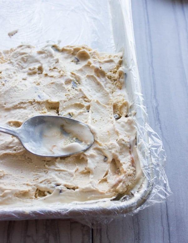 salted caramel ice cream being spread in a baking dish to make ice cream cakes