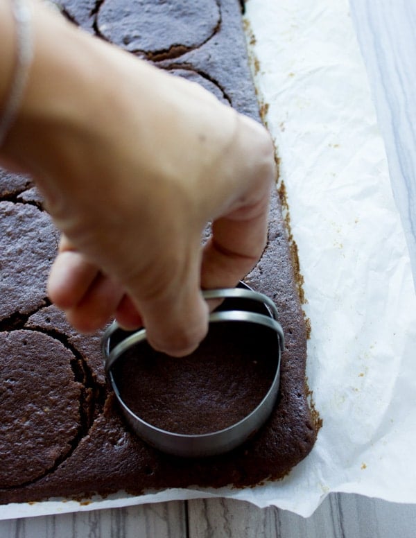 rounds being cut of of a chocolate cake with a cookie cutter