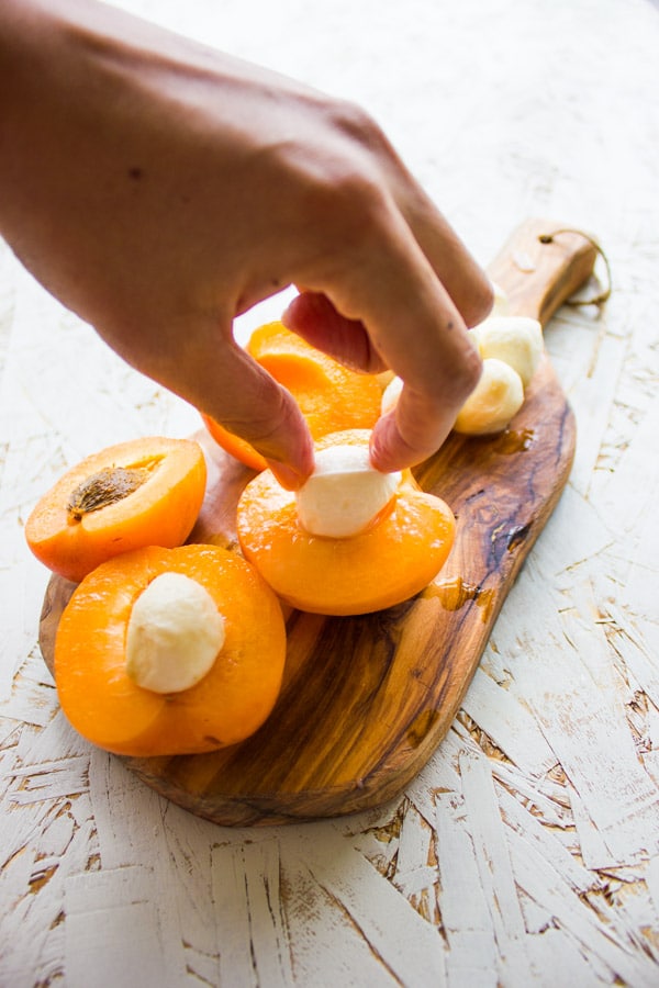 apricot halves being stuffed with mini mozzarella balls 