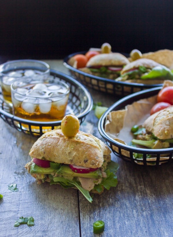 Spicy Chunky Tuna Sandwiches served on a rustic wooden table with some drinks on the side