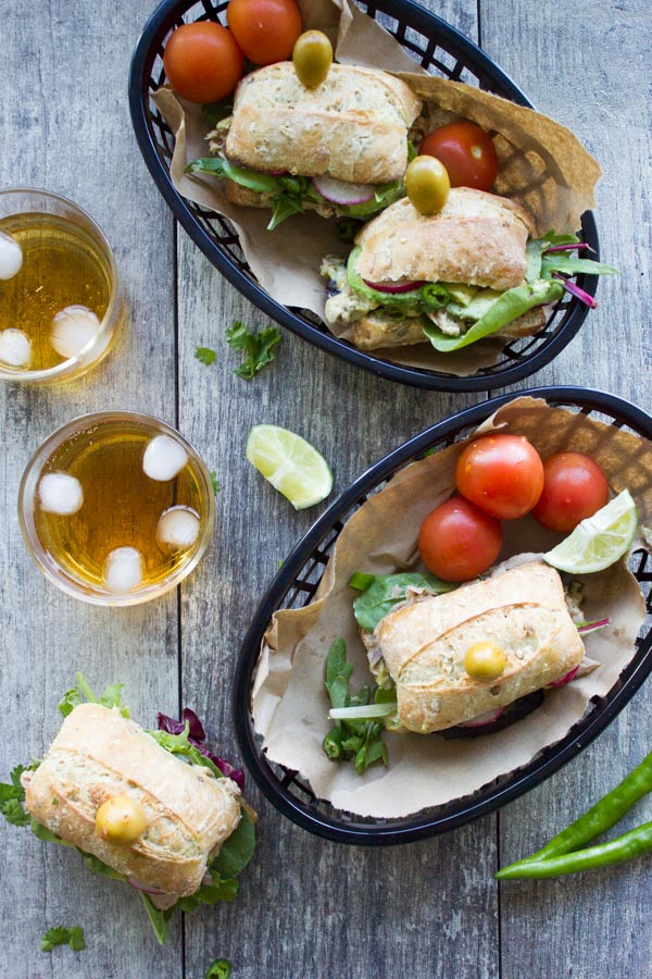 Spicy Chunky Tuna Sandwiches served in black bread baskets with some cool drinks on the side