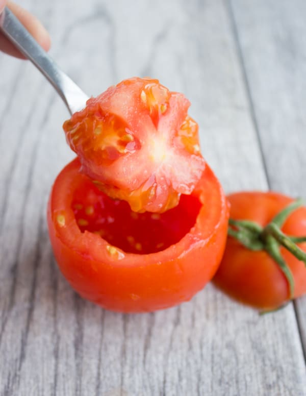 a tomato being hollowed out
