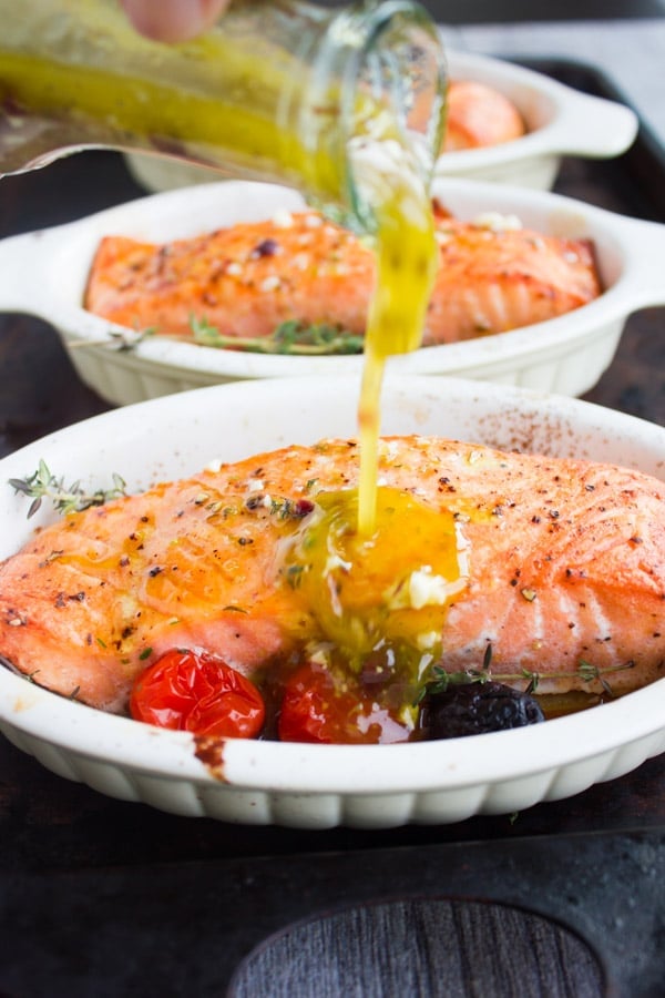 Freshly Baked Salmon Fillets being drizzled with Greek Dressing
