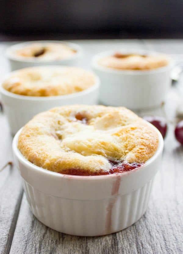 side view of a small ramekin with Sweet Cherry Buckle with some cherry juice running down the side
