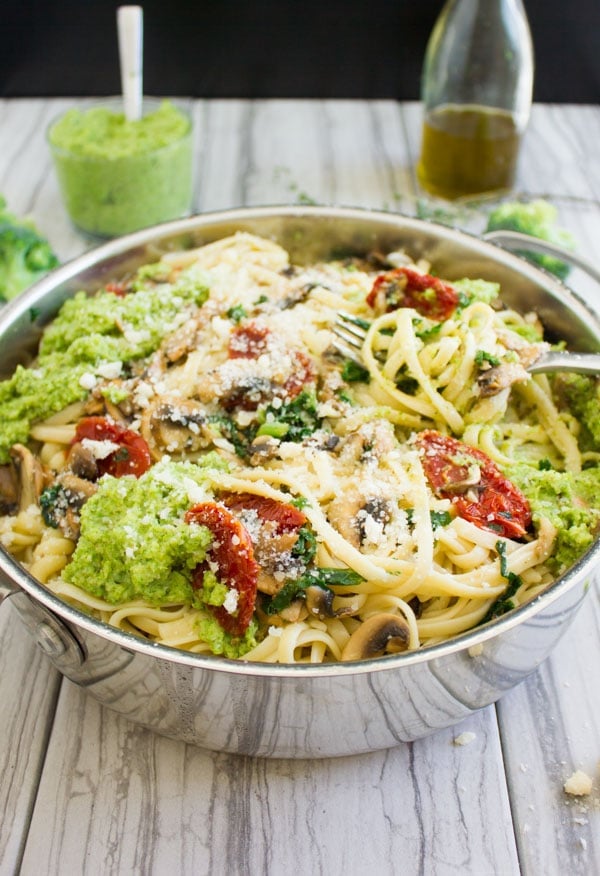 close-up of a skillet with healthy sauteed pasta topped with dollops of broccoli pesto
