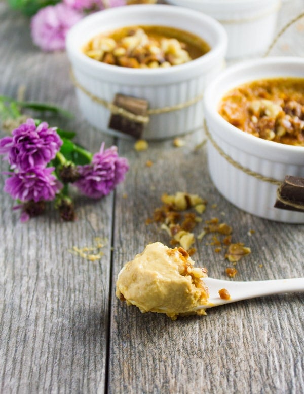 A spoon on a table with some caramel pudding inside