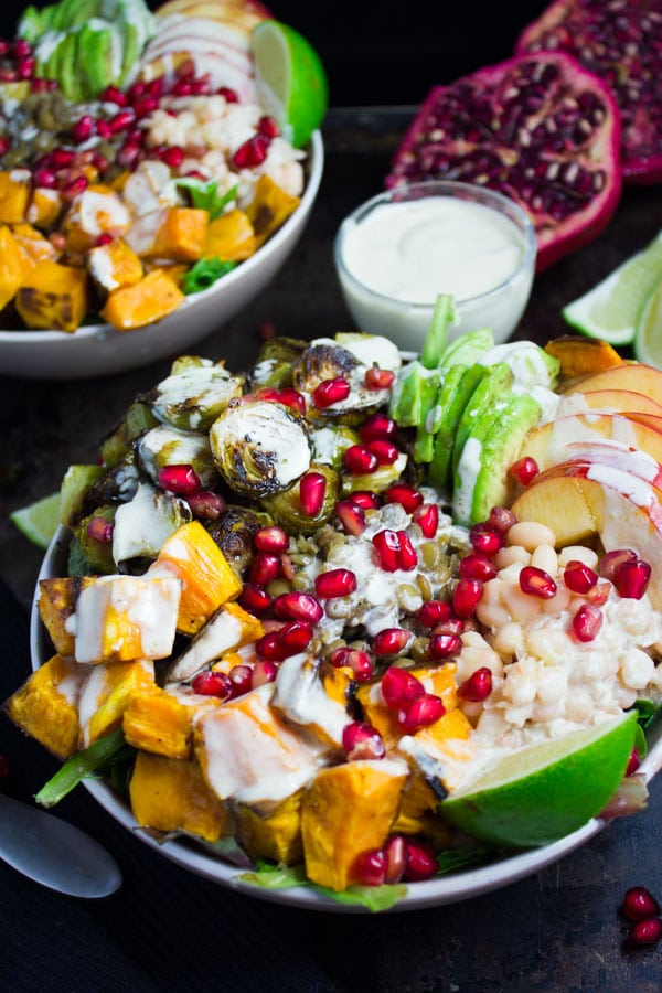 Lentil Fall Harvest Buddha Bowl topped with roasted brussels sprouts, apples, roasted sweet potatoes and pomegranate arils