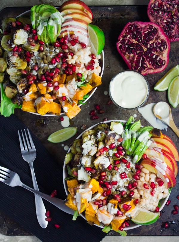 Lentil Fall Harvest Buddha Bowl. This easy, crazy delicious Buddha goodness bowl is all you need to make your life happier! Loaded with greens, lentils, navy beans, apples, avocado, sweet potatoes, sprouts, pomegranate arils--all drizzled with the perfect tahini sauce! Get this recipe and tips for Buddha bowl perfection. www.twopurplefigs.com