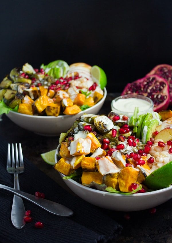 Lentil Fall Harvest Buddha Bowls drizzled with tahini dressing and sprinkled with pomegranate arils