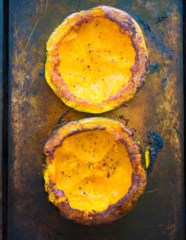 oven roasted halved kabocha squash on a baking sheet 