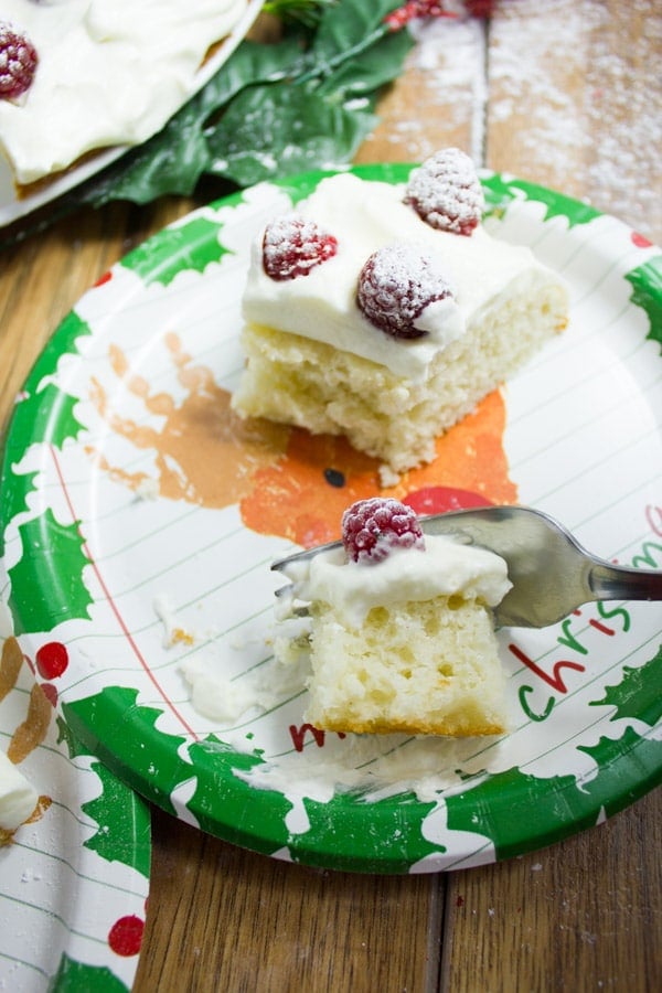 a half eaten piece of vanilla raspberry holiday cake on a festive Christmas plate