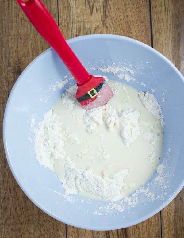 buttermilk being added to the dry ingredients for making a vanilla cake