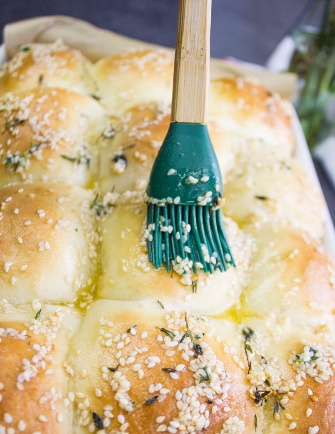 brushing dinner rolls with butter mixture